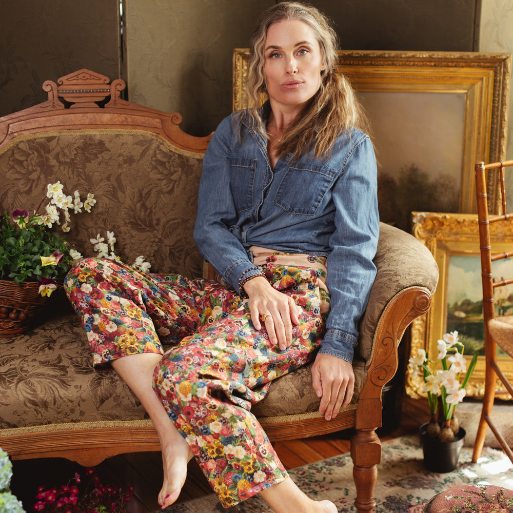 
                  
                    Artist pants featuring a whimsical print of 50 antique seed catalogue flowers arranged on a painter’s palette with a Monet quote – Market of Stars.
                  
                