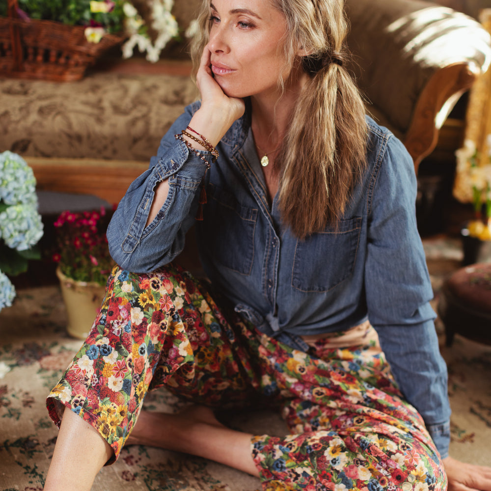 
                  
                    Artist pants featuring a whimsical print of 50 antique seed catalogue flowers arranged on a painter’s palette with a Monet quote – Market of Stars.
                  
                