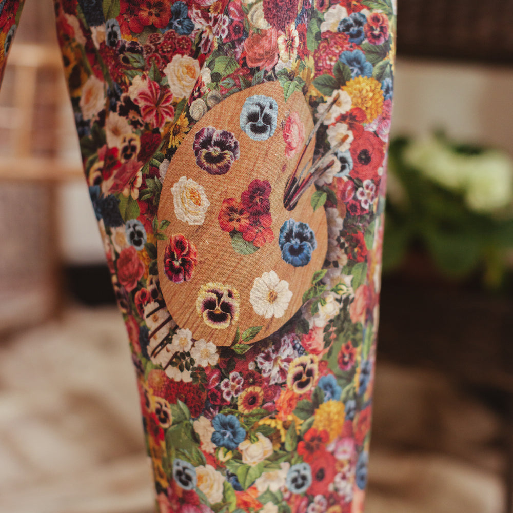 
                  
                    Artist pants featuring a whimsical print of 50 antique seed catalogue flowers arranged on a painter’s palette with a Monet quote – Market of Stars.
                  
                
