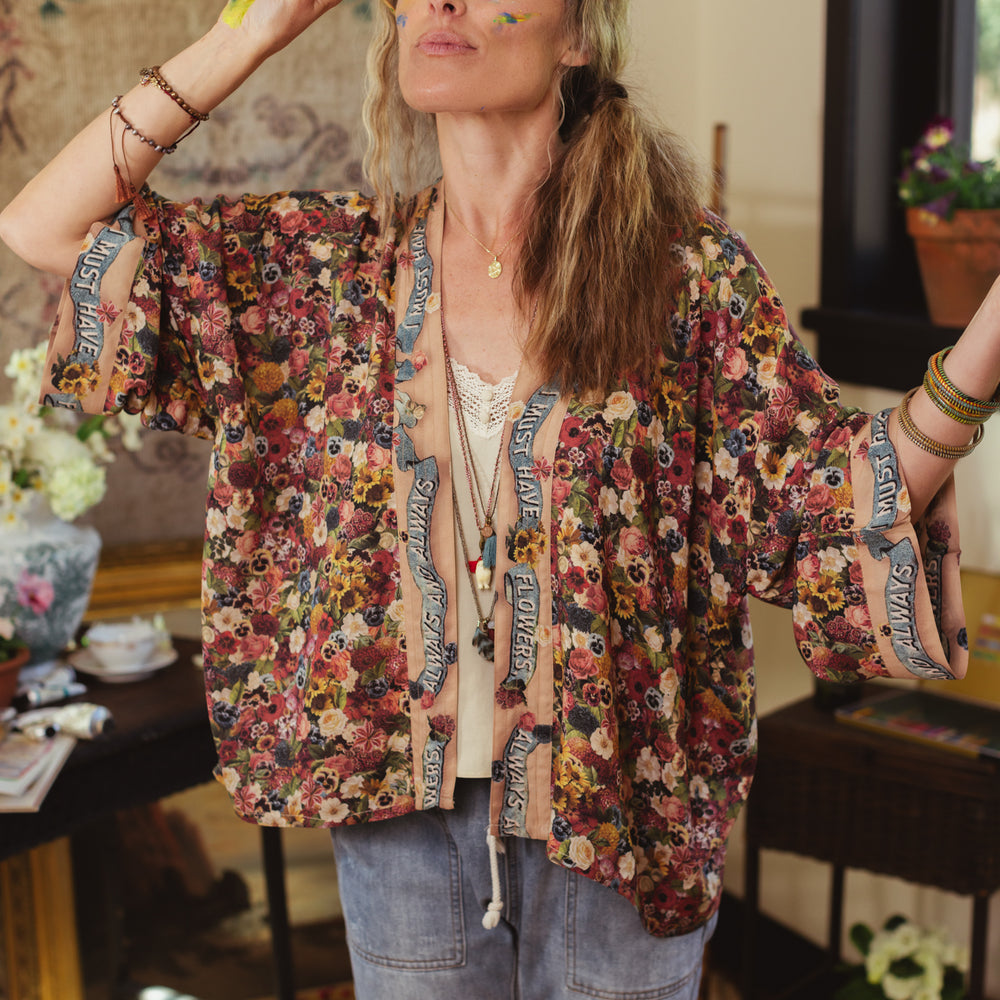 
                  
                    Short kimono featuring a whimsical artist’s palette and over 50 layered flowers from antique seed catalogues, inspired by Claude Monet – Market of Stars.
                  
                