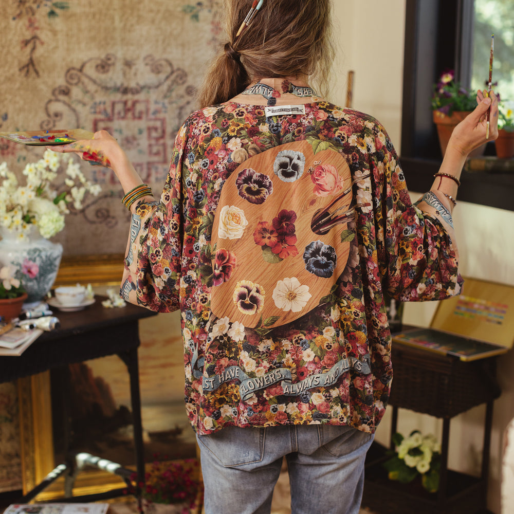 
                  
                    Short kimono featuring a whimsical artist’s palette and over 50 layered flowers from antique seed catalogues, inspired by Claude Monet – Market of Stars.
                  
                