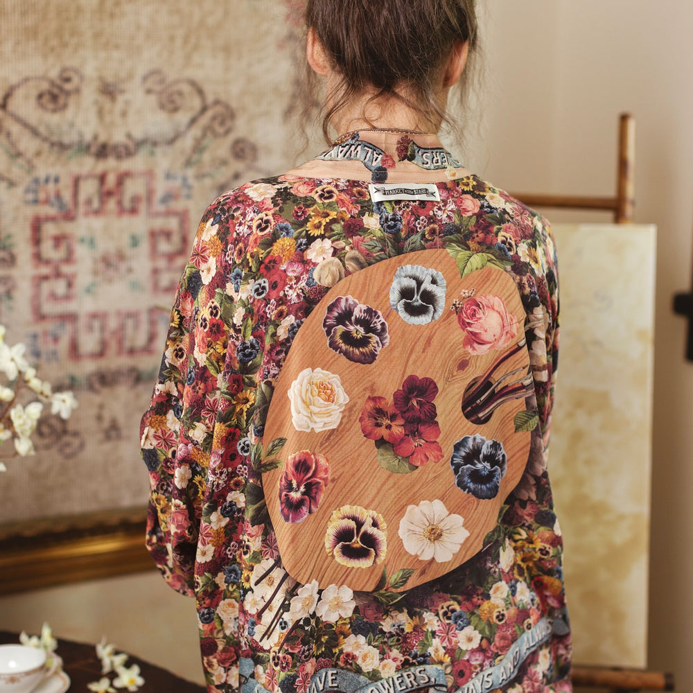 
                  
                    Short kimono featuring a whimsical artist’s palette and over 50 layered flowers from antique seed catalogues, inspired by Claude Monet – Market of Stars.
                  
                