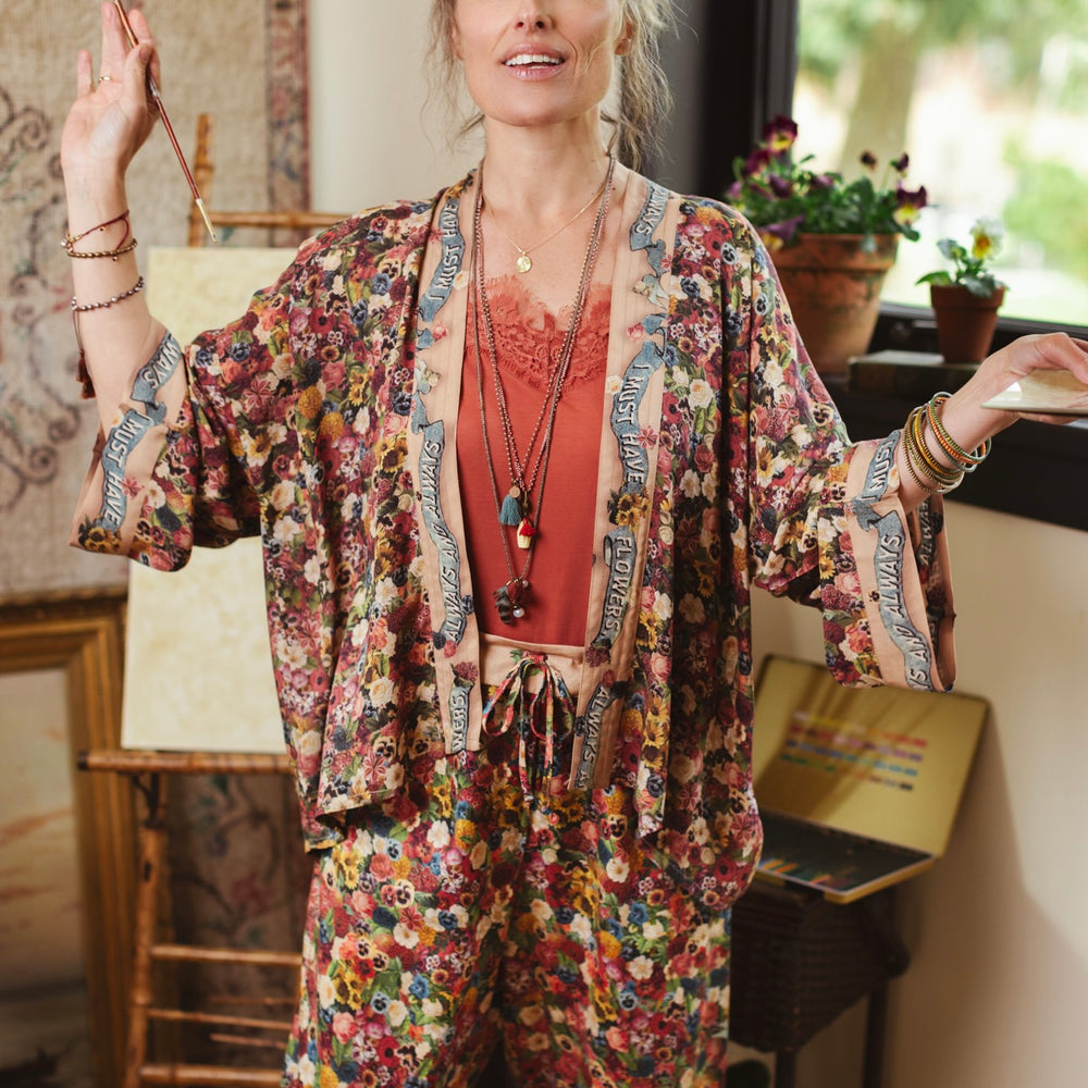 
                  
                    Short kimono featuring a whimsical artist’s palette and over 50 layered flowers from antique seed catalogues, inspired by Claude Monet – Market of Stars.
                  
                