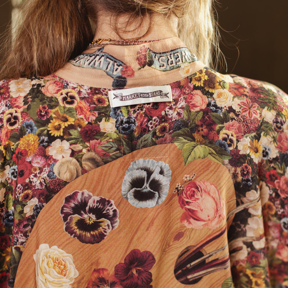 
                  
                    Short kimono featuring a whimsical artist’s palette and over 50 layered flowers from antique seed catalogues, inspired by Claude Monet – Market of Stars.
                  
                
