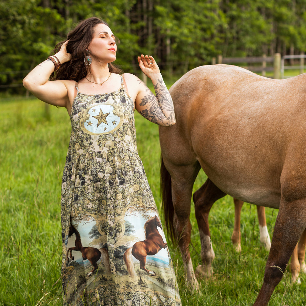 
                  
                    Model wearing a bamboo-viscose maxi-length slip dress made for everyday adventures with a whimsical print celebrating one's unbridled spirit of adventure - Market of Stars
                  
                
