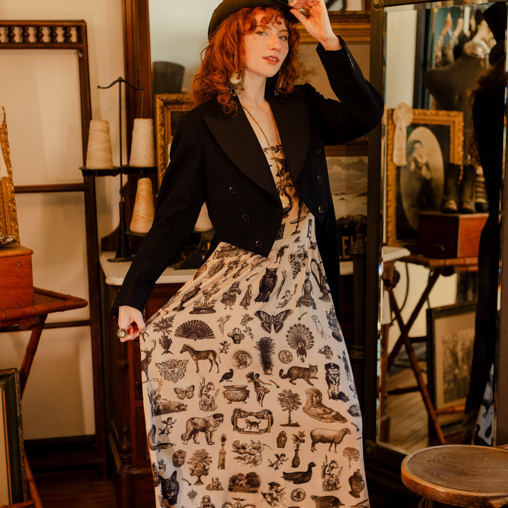 
                  
                    Model wearing a maxi-length bamboo viscose slip dress inspired by a mysterious Victorian scrapbook. This whimsical print celebrates the wonder hidden in ordinary things — Market of Stars.
                  
                