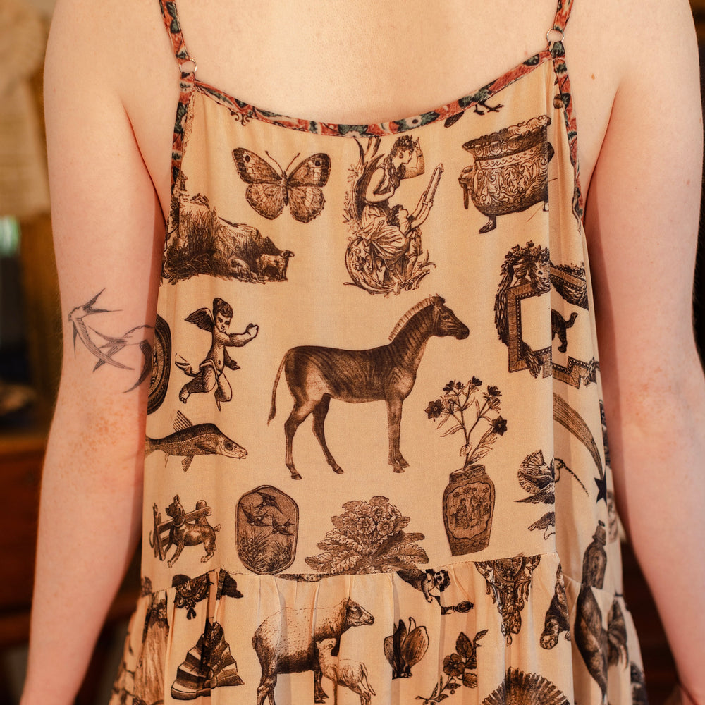 
                  
                    Model wearing a maxi-length bamboo viscose slip dress inspired by a mysterious Victorian scrapbook. This whimsical print celebrates the wonder hidden in ordinary things — Market of Stars.
                  
                