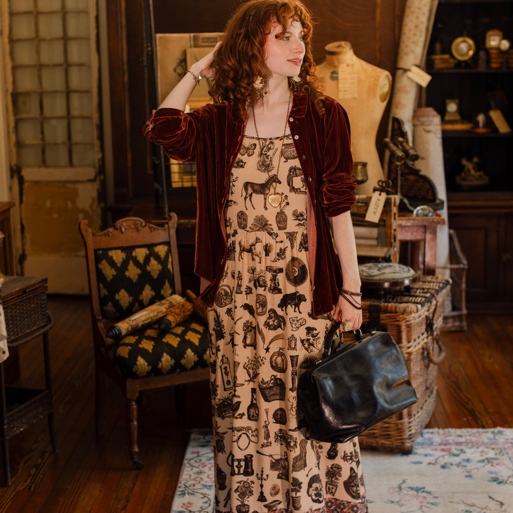 
                  
                    Model wearing a maxi-length bamboo viscose slip dress inspired by a mysterious Victorian scrapbook. This whimsical print celebrates the wonder hidden in ordinary things — Market of Stars.
                  
                