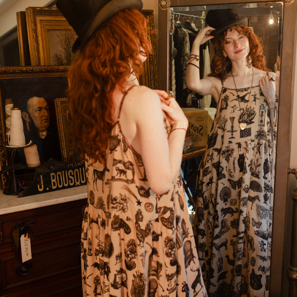 
                  
                    Model wearing a maxi-length bamboo viscose slip dress inspired by a mysterious Victorian scrapbook. This whimsical print celebrates the wonder hidden in ordinary things — Market of Stars.
                  
                