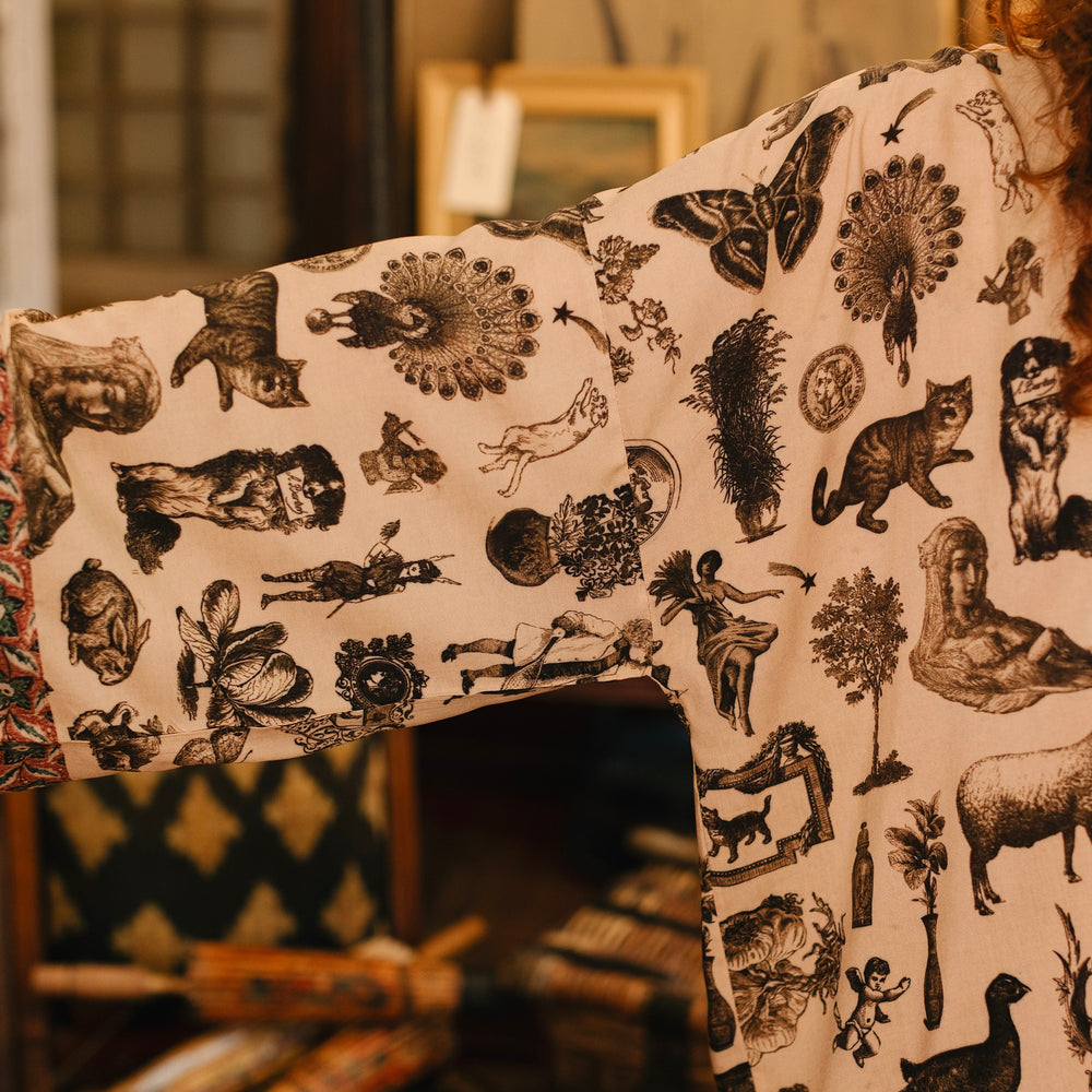 
                  
                    Model wearing a bamboo-viscose cropped length duster inspired by a mysterious Victorian scrapbook. This whimsical print celebrates the wonder hidden in ordinary things — Market of Stars.
                  
                