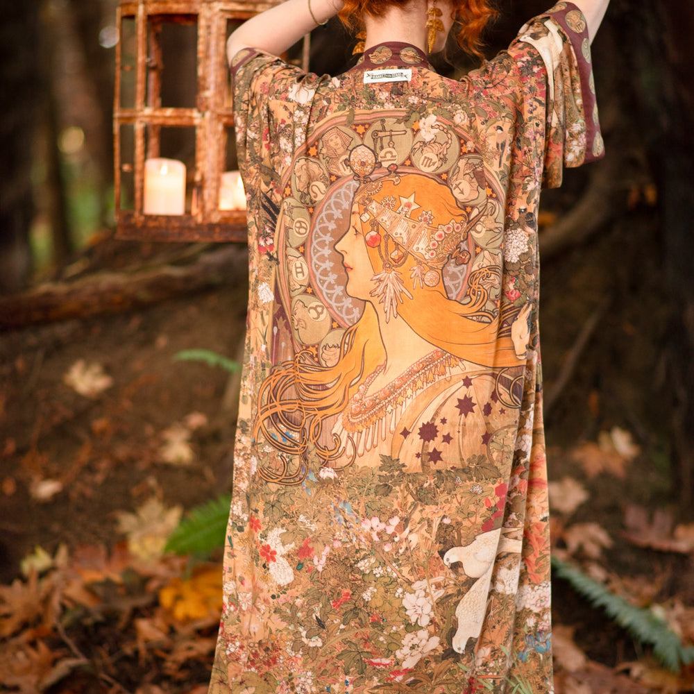 Model wearing Dreamweaver Opera Duster – featuring Alphonse Mucha’s zodiac woman, celestial crown, and burgundy zodiac trim inspired by 1970s luxe bohemian style – Market of Stars.