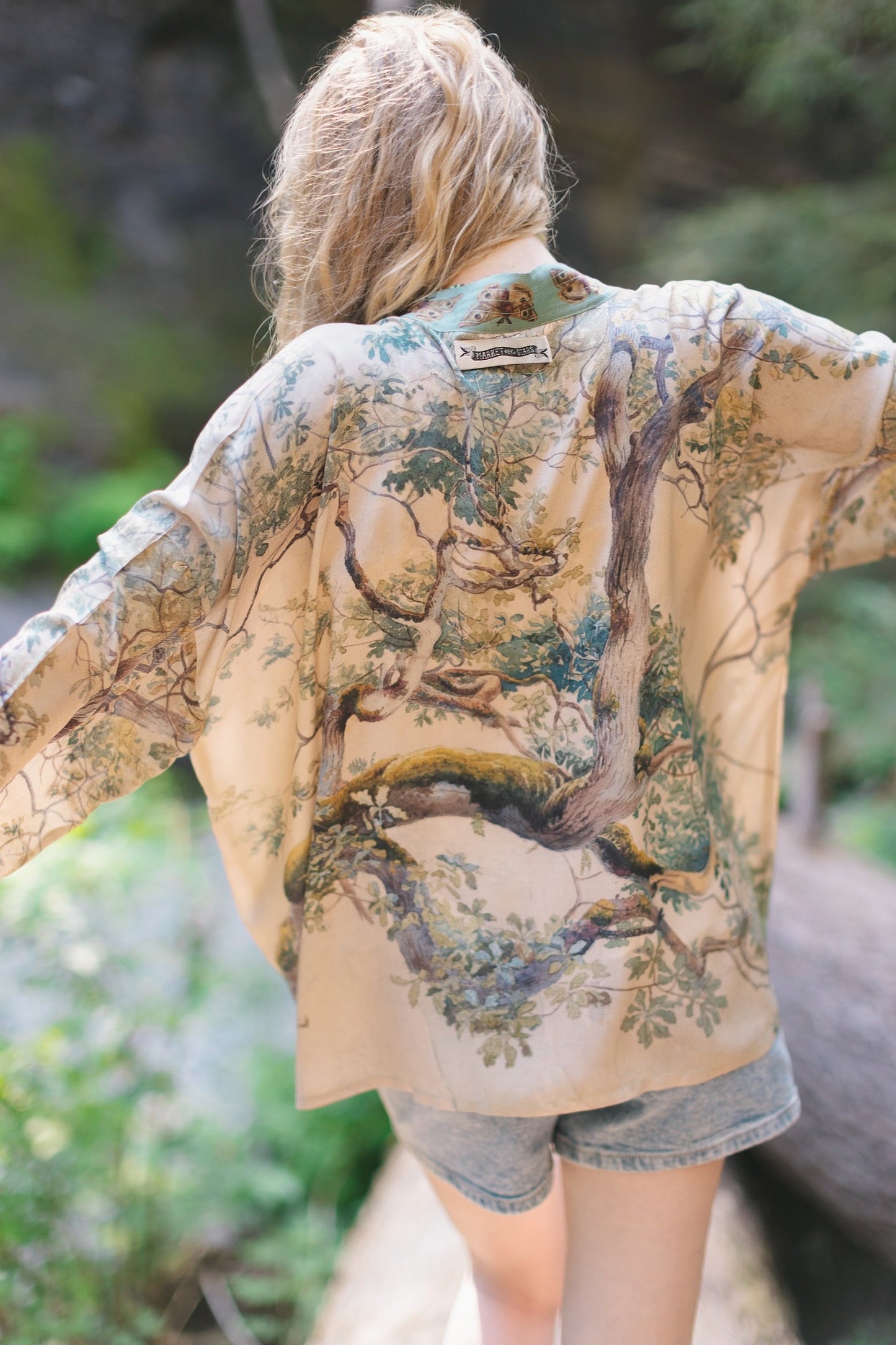 Model wearing Earth and Sky Pixie Duster featuring Charles Aston’s tree art and antique moth illustrations – a soft, nature-inspired layering piece – Market of Stars.