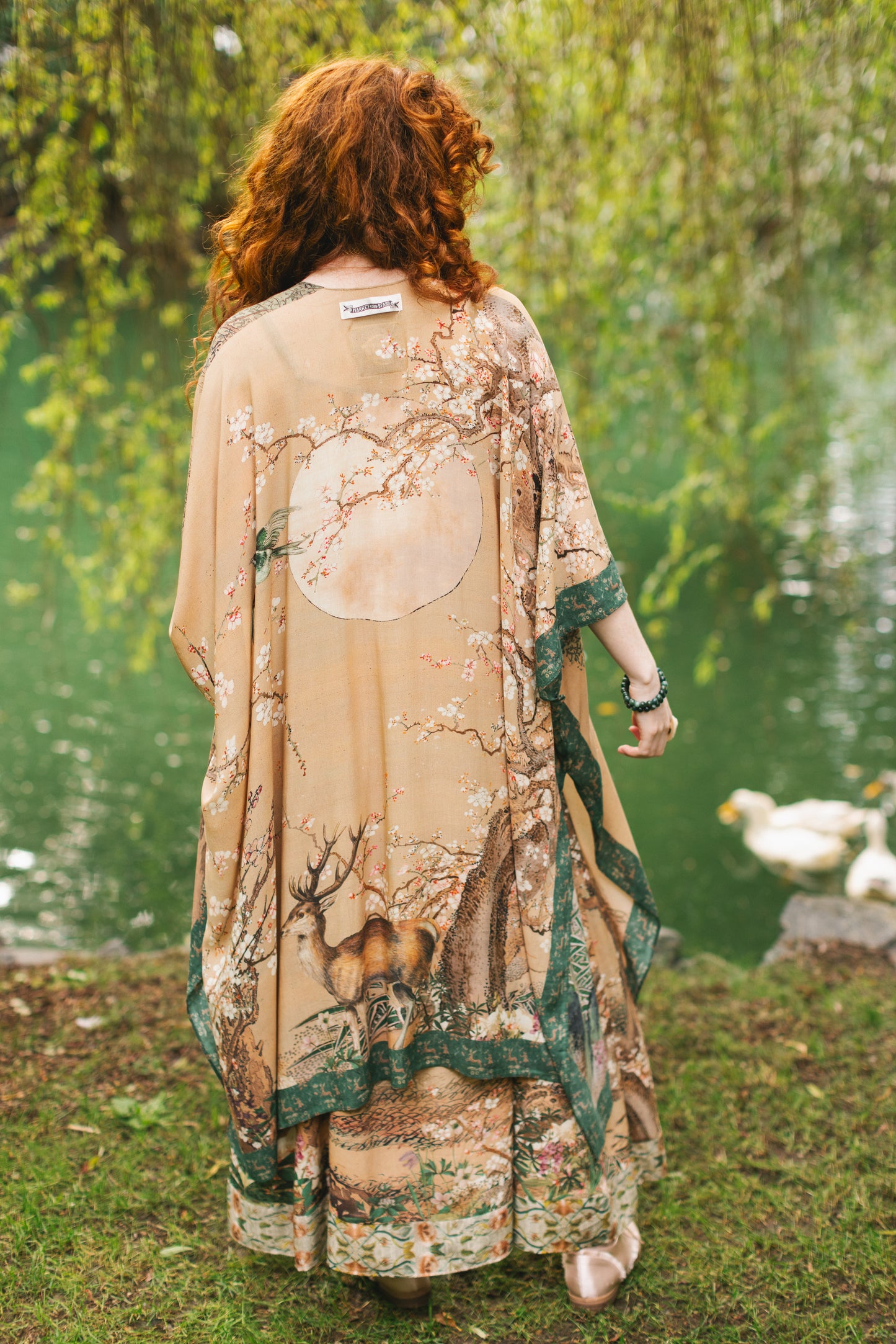 Model wearing Fable Goddess Duster featuring antique Japanese art, cherry and peach blossoms, nightingales, deer, and French block prints - Market of Stars