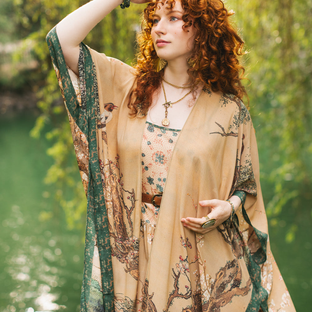 
                  
                    Model wearing Fable Goddess Duster featuring antique Japanese art, cherry and peach blossoms, nightingales, deer, and French block prints - Market of Stars
                  
                