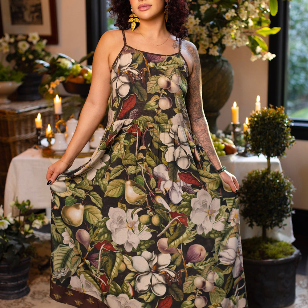 Model wearing a maxi-length slip dress featuring vintage magnolia lithographs, delicate moth etchings, and charming bumblebee trim - Market of Stars