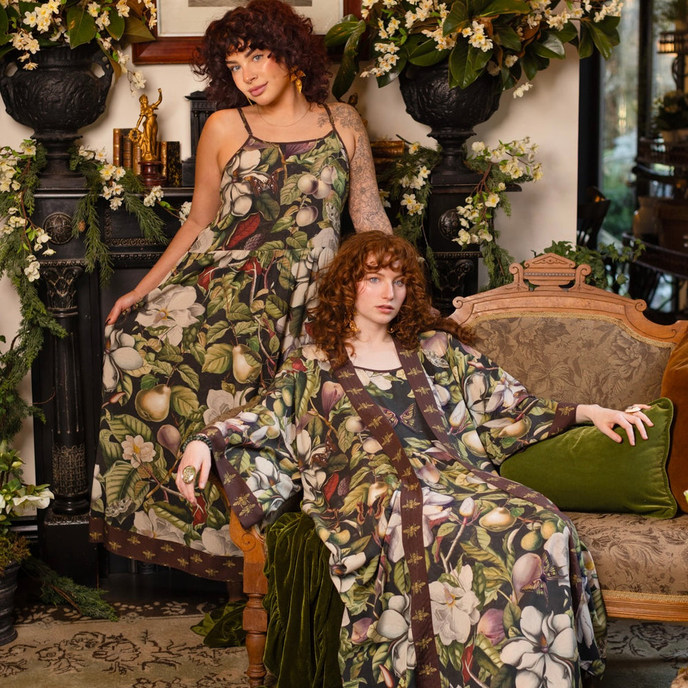 Model wearing a maxi-length slip dress featuring vintage magnolia lithographs, delicate moth etchings, and charming bumblebee trim - Market of Stars