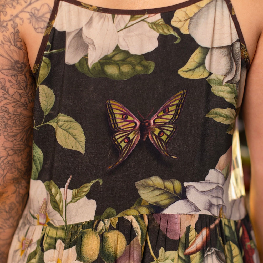 
                  
                    Model wearing a maxi-length slip dress featuring vintage magnolia lithographs, delicate moth etchings, and charming bumblebee trim - Market of Stars
                  
                