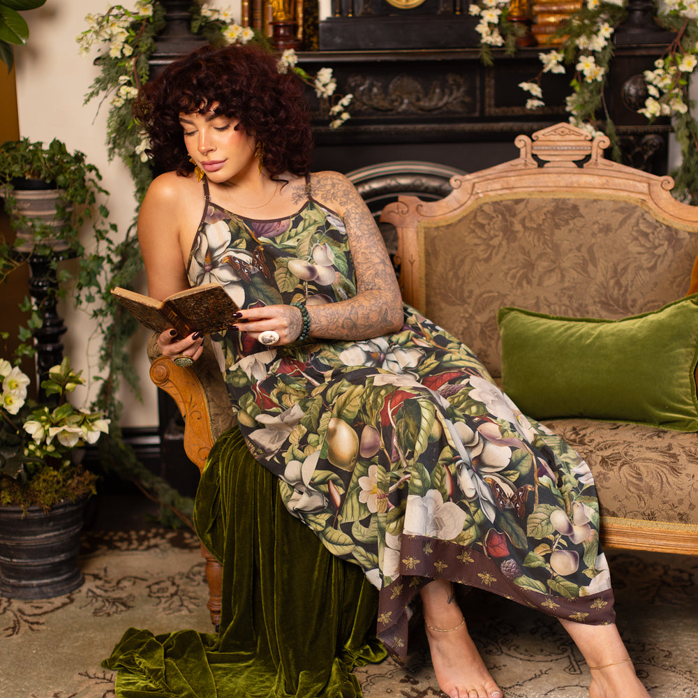 
                  
                    Model wearing a maxi-length slip dress featuring vintage magnolia lithographs, delicate moth etchings, and charming bumblebee trim - Market of Stars
                  
                