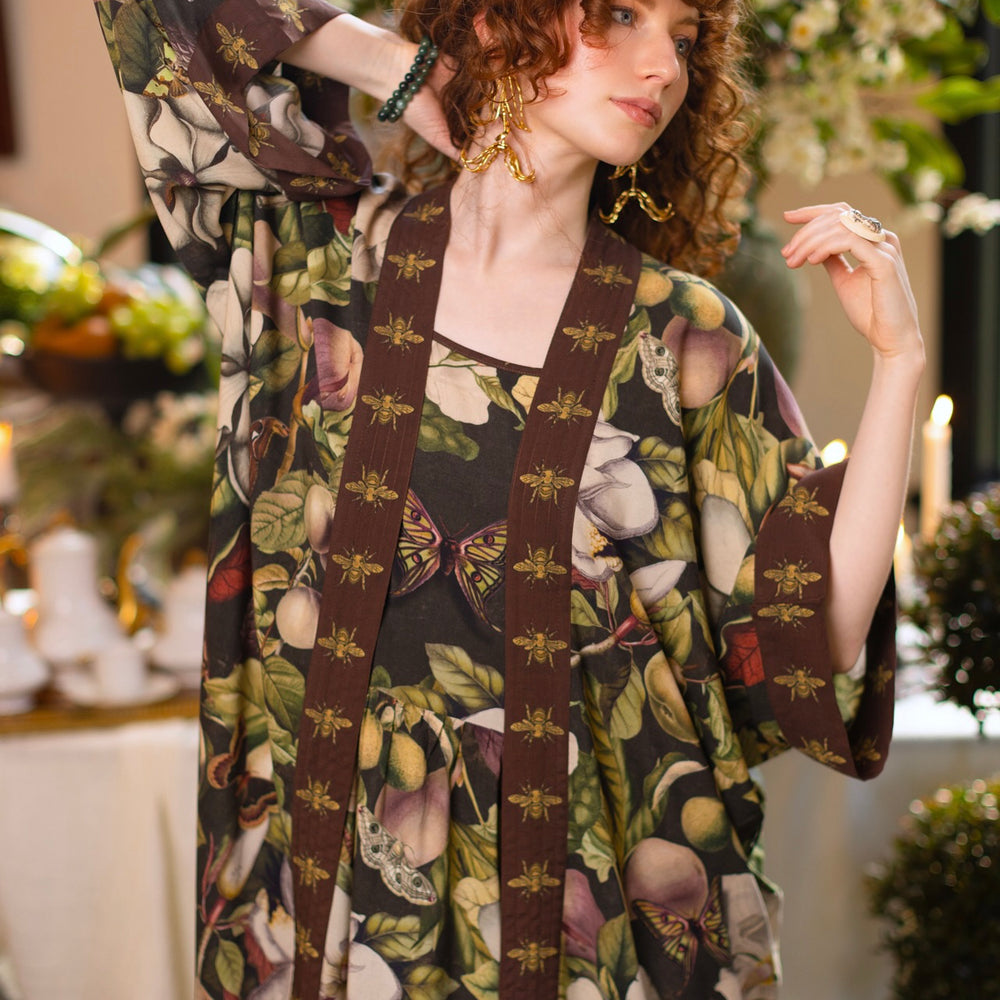
                  
                    Model wearing a maxi-length slip dress featuring vintage magnolia lithographs, delicate moth etchings, and charming bumblebee trim - Market of Stars
                  
                