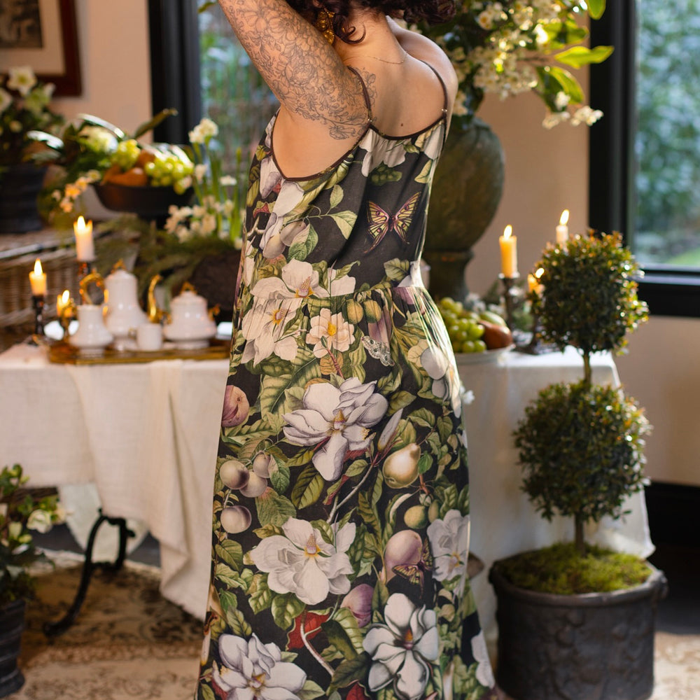 
                  
                    Model wearing a maxi-length slip dress featuring vintage magnolia lithographs, delicate moth etchings, and charming bumblebee trim - Market of Stars
                  
                