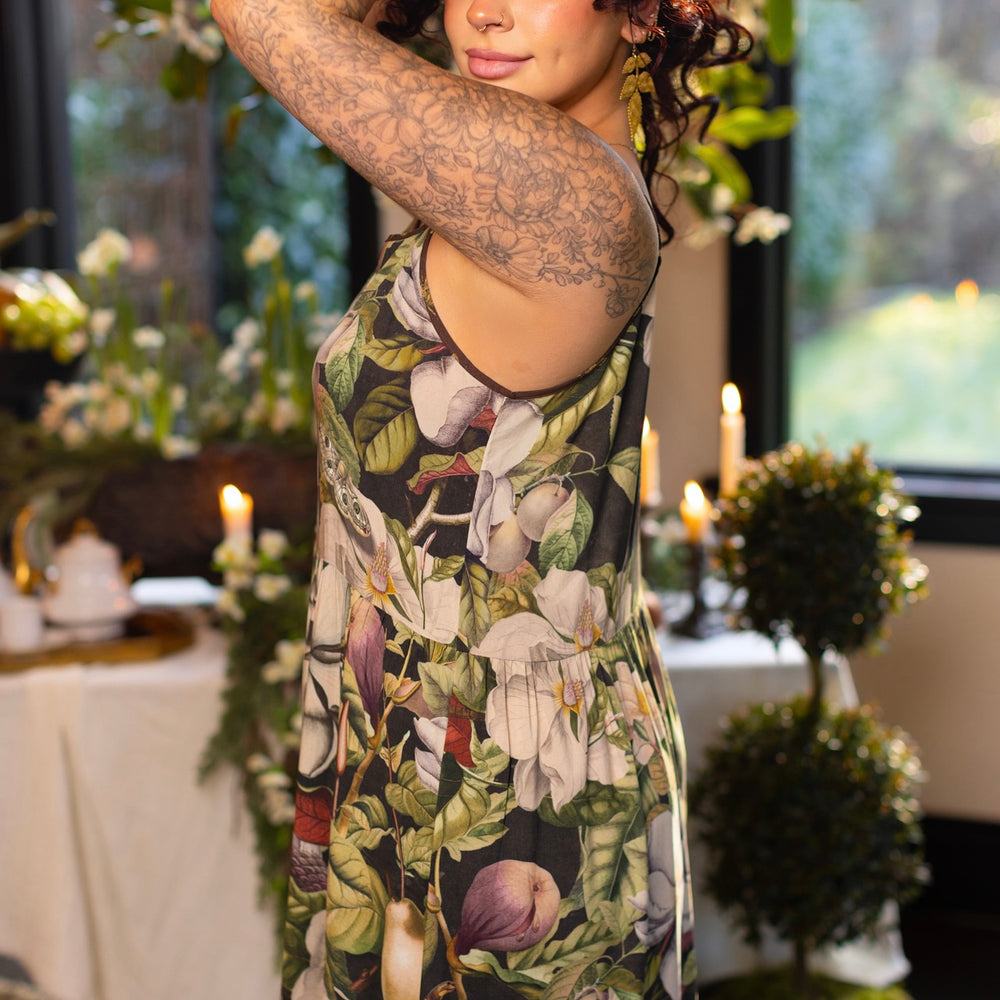 
                  
                    Model wearing a maxi-length slip dress featuring vintage magnolia lithographs, delicate moth etchings, and charming bumblebee trim - Market of Stars
                  
                