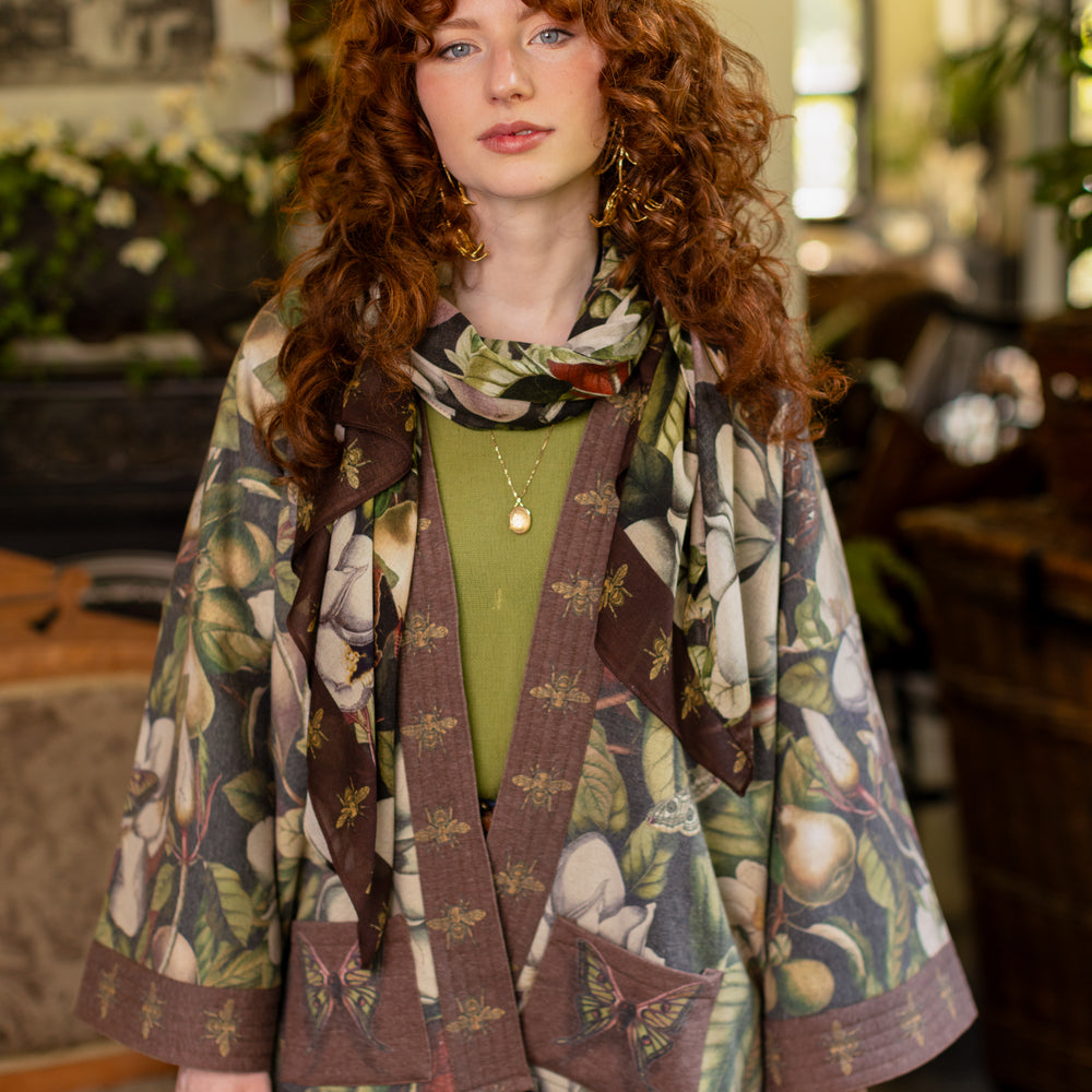 Model wearing a cozy cardigan lined with fleece featuring vintage magnolia lithographs, delicate moth etchings, and charming bumblebee trim - Market of stars
