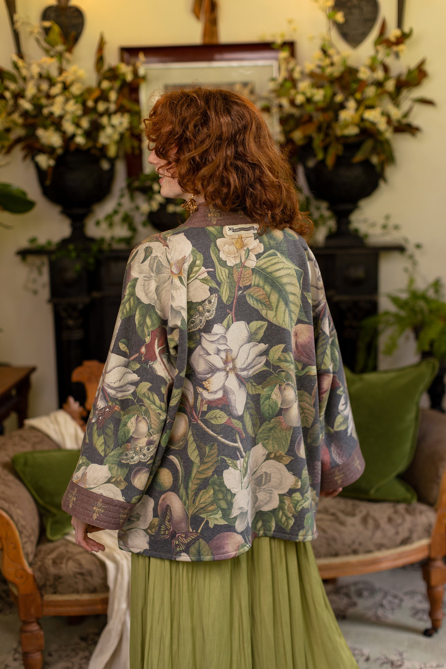 Model wearing a cozy cardigan lined with fleece featuring vintage magnolia lithographs, delicate moth etchings, and charming bumblebee trim - Market of stars