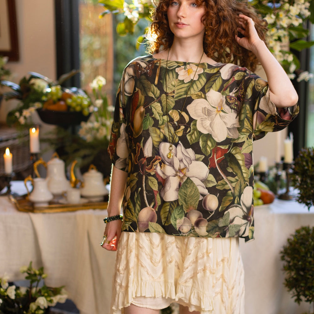 
                  
                    Model wearing the Fleur De Lune Luxe Tee with wide scoop neck and soft bamboo-based viscose, featuring vintage magnolia lithographs, delicate moth etchings, and bumblebee trim - Market of Stars
                  
                