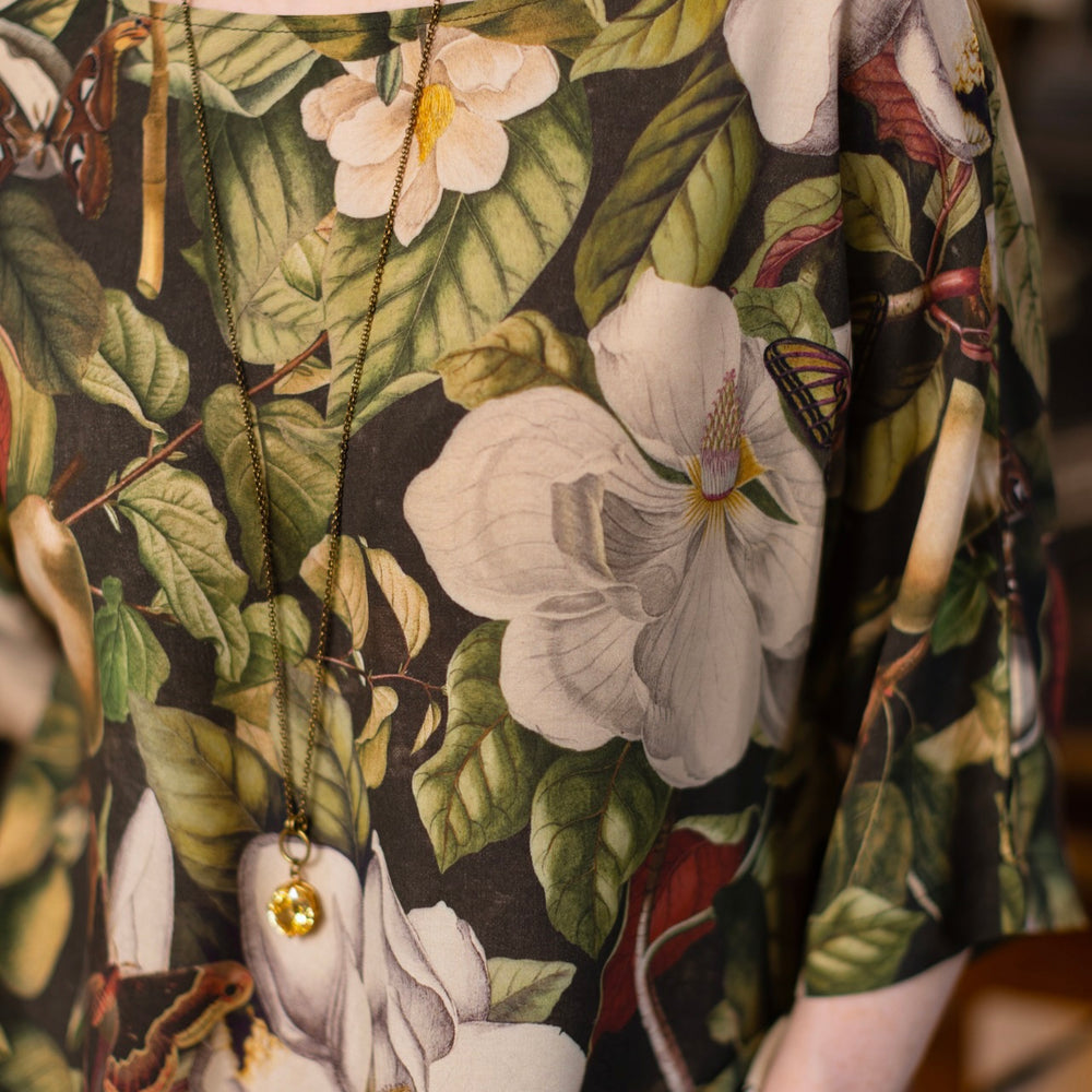 
                  
                    Model wearing the Fleur De Lune Luxe Tee with wide scoop neck and soft bamboo-based viscose, featuring vintage magnolia lithographs, delicate moth etchings, and bumblebee trim - Market of Stars
                  
                