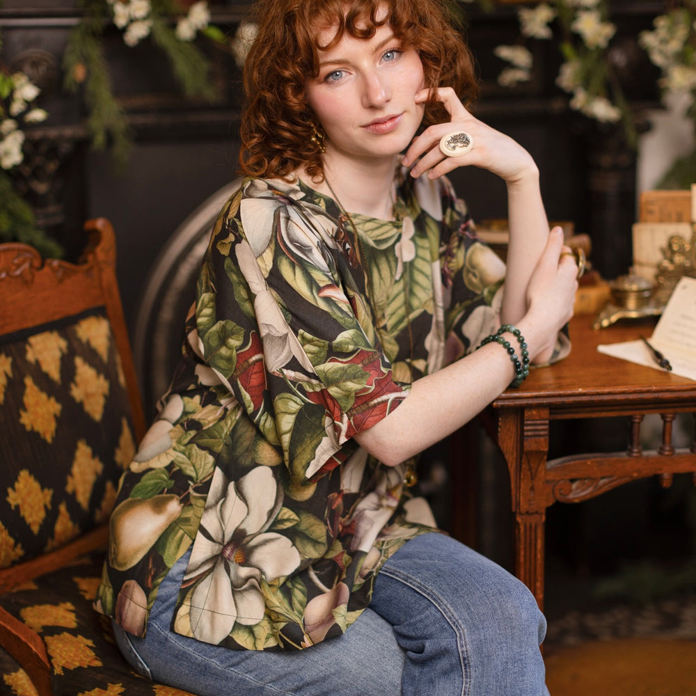 
                  
                    Model wearing the Fleur De Lune Luxe Tee with wide scoop neck and soft bamboo-based viscose, featuring vintage magnolia lithographs, delicate moth etchings, and bumblebee trim - Market of Stars
                  
                