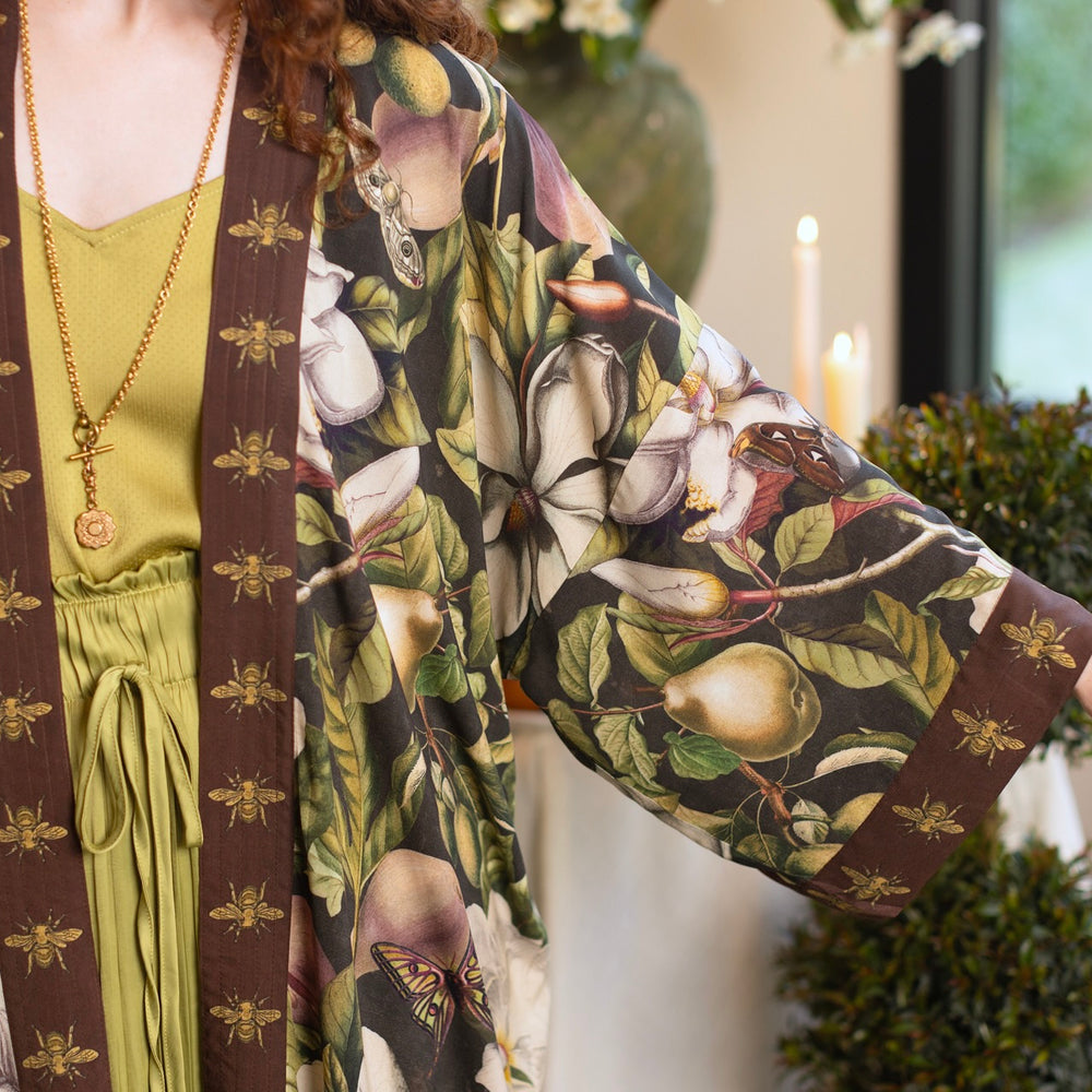 
                  
                    Model wearing a full length kimono duster robe featuring vintage magnolia lithographs, delicate moth etchings, and charming bumblebee trim - Market of Stars
                  
                