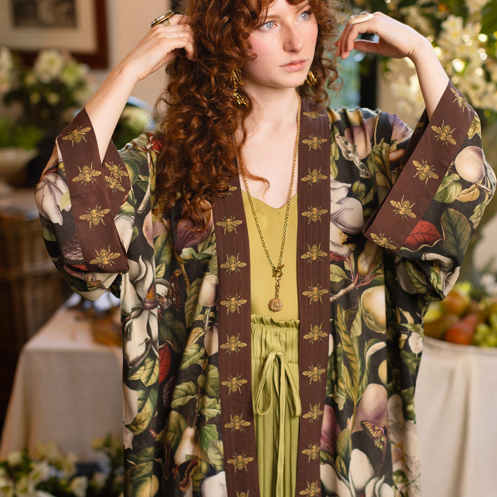
                  
                    Model wearing a full length kimono duster robe featuring vintage magnolia lithographs, delicate moth etchings, and charming bumblebee trim - Market of Stars
                  
                