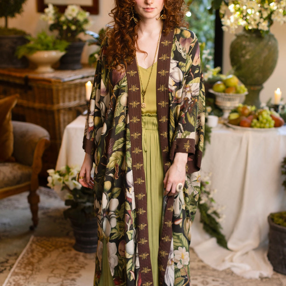 
                  
                    Model wearing a full length kimono duster robe featuring vintage magnolia lithographs, delicate moth etchings, and charming bumblebee trim - Market of Stars
                  
                