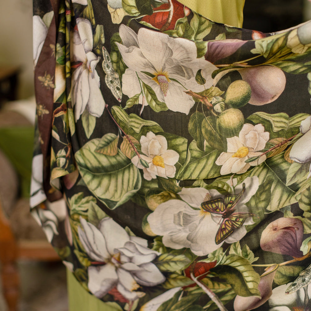 
                  
                    Model wearing a lightweight bamboo viscose scarf featuring vintage magnolia lithographs, delicate moth etchings and charming bumblebee trim - Market of Stars
                  
                