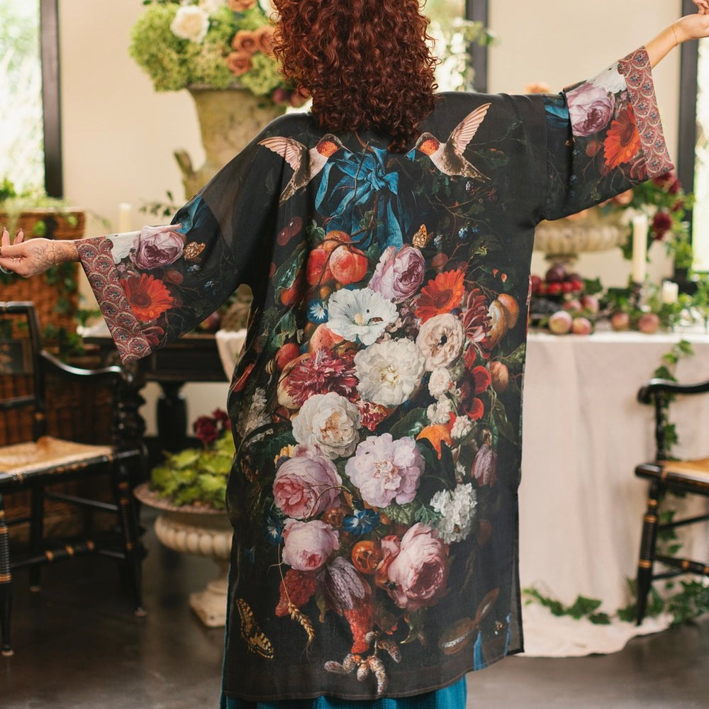 Model showcasing the Flight of Fancy Opera Robe featuring vibrant hummingbirds and historic floral paintings by Rachel Ruysch – Market of Stars.