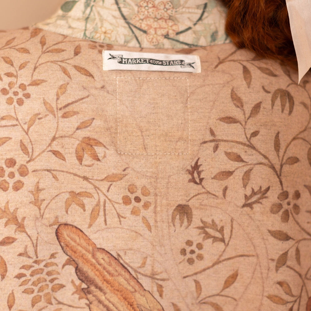 
                  
                    Model in cozy Folklore cottage cardigan featuring Bird-of-Peace embroidery and unfinished William Morris textile art in soft earthy tones – Market of Stars.
                  
                