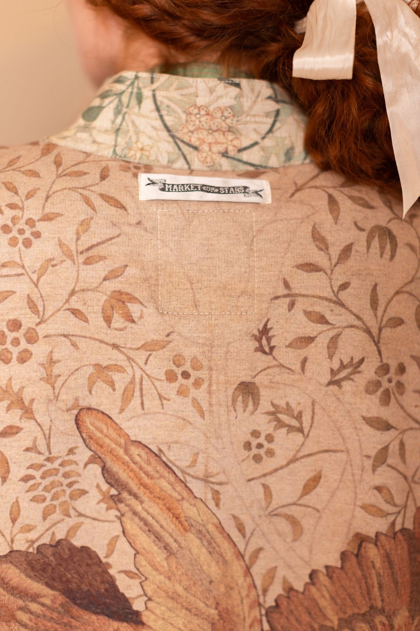 Model in cozy Folklore cottage cardigan featuring Bird-of-Peace embroidery and unfinished William Morris textile art in soft earthy tones – Market of Stars.