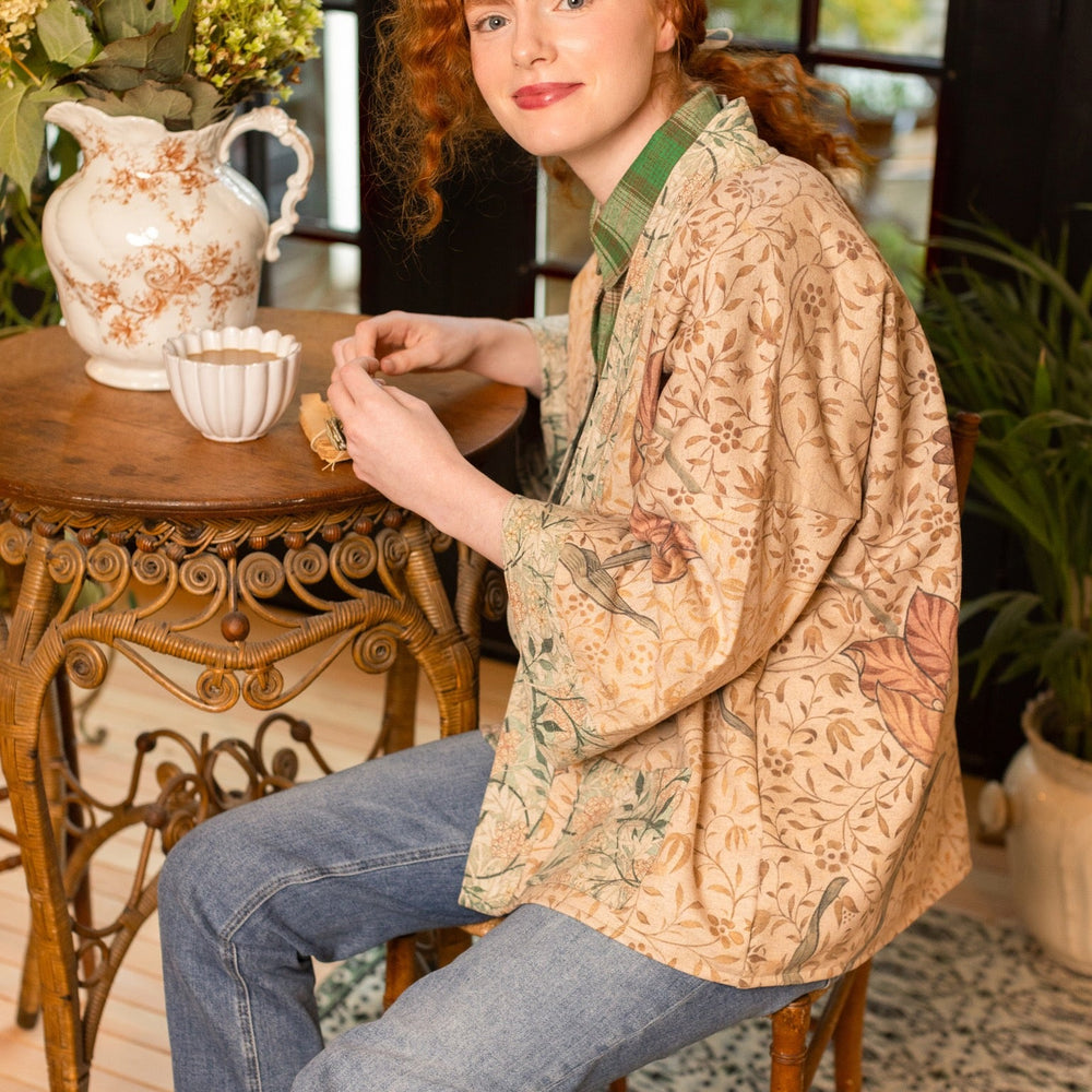 
                  
                    Model in cozy Folklore cottage cardigan featuring Bird-of-Peace embroidery and unfinished William Morris textile art in soft earthy tones – Market of Stars.
                  
                