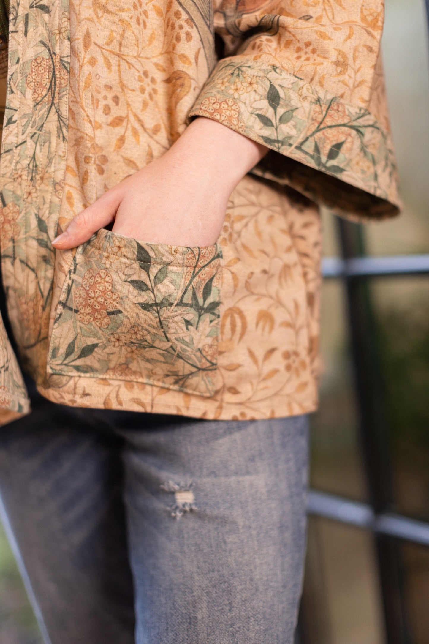 Model in cozy Folklore cottage cardigan featuring Bird-of-Peace embroidery and unfinished William Morris textile art in soft earthy tones – Market of Stars.