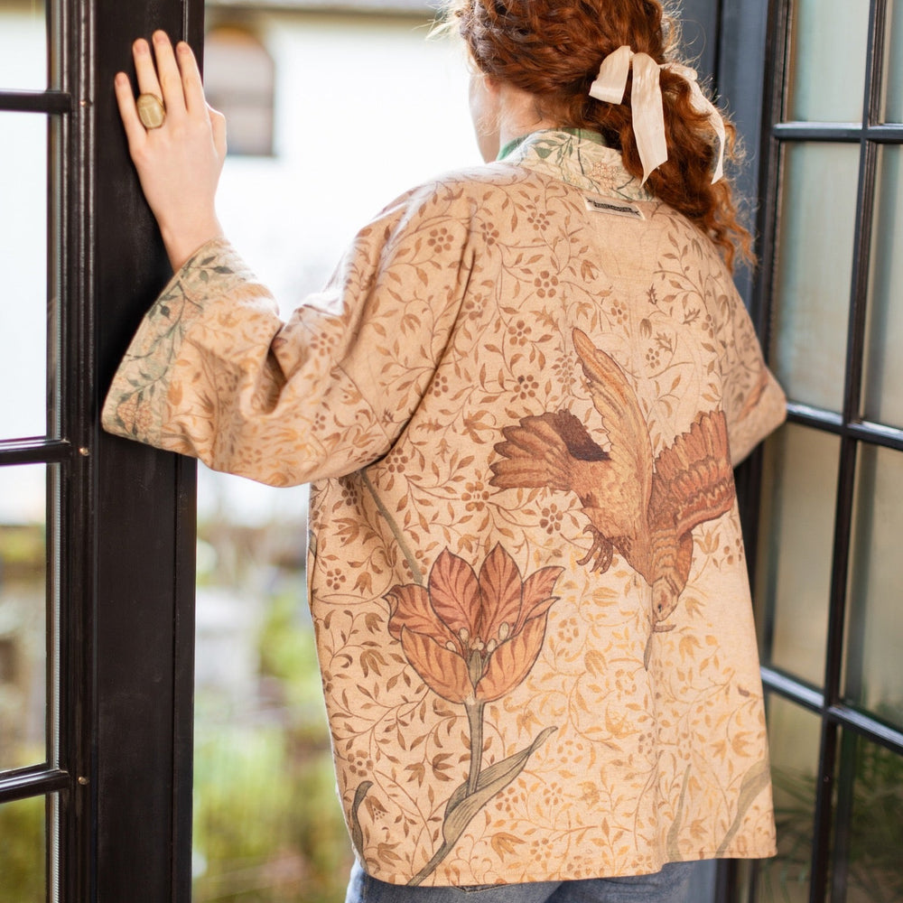 
                  
                    Model in cozy Folklore cottage cardigan featuring Bird-of-Peace embroidery and unfinished William Morris textile art in soft earthy tones – Market of Stars.
                  
                