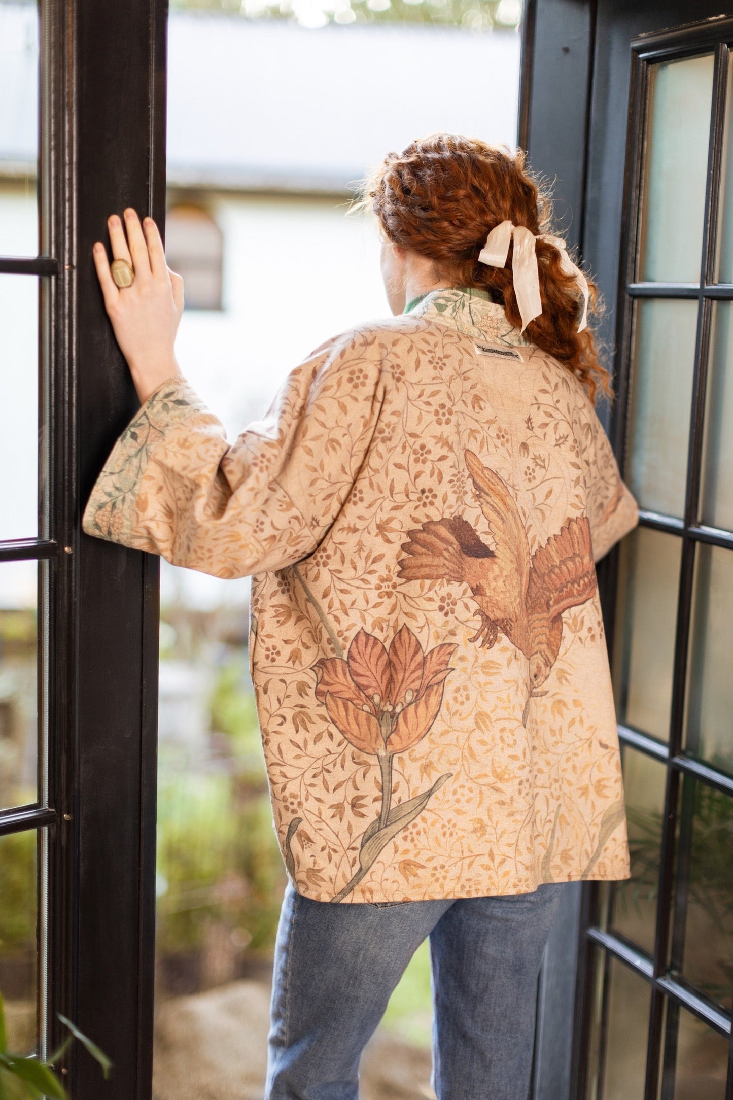 Model in cozy Folklore cottage cardigan featuring Bird-of-Peace embroidery and unfinished William Morris textile art in soft earthy tones – Market of Stars.