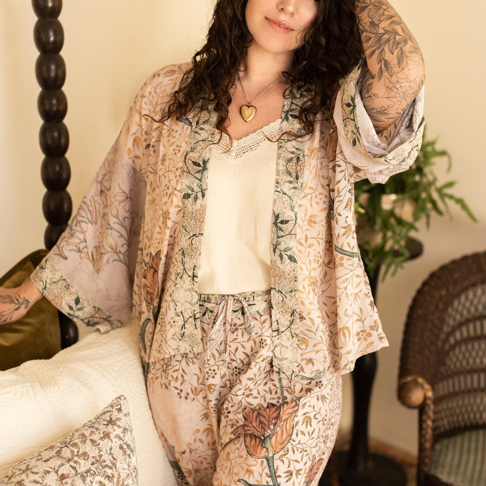 
                  
                    Model wearing full-length Folklore opera duster featuring Bird-of-Peace embroidery and unfinished William Morris textile panels in soft earthy tones – Market of Stars.
                  
                
