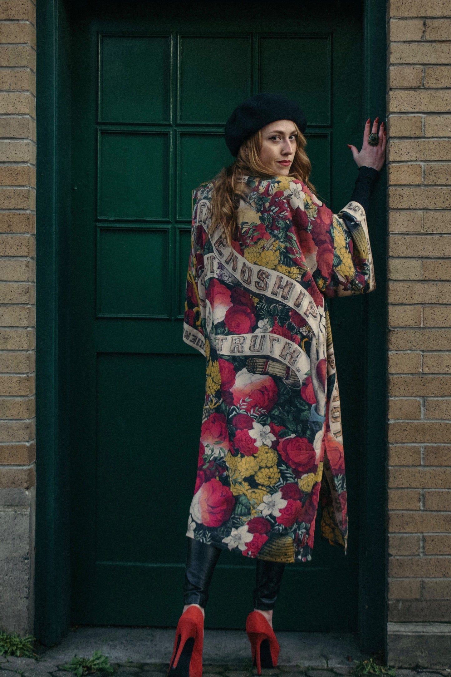 Model wearing our long, eclectic opera duster featuring vintage symbols of love, kindness, and truth in a bold archive-inspired print with removable belt – Market of Stars.