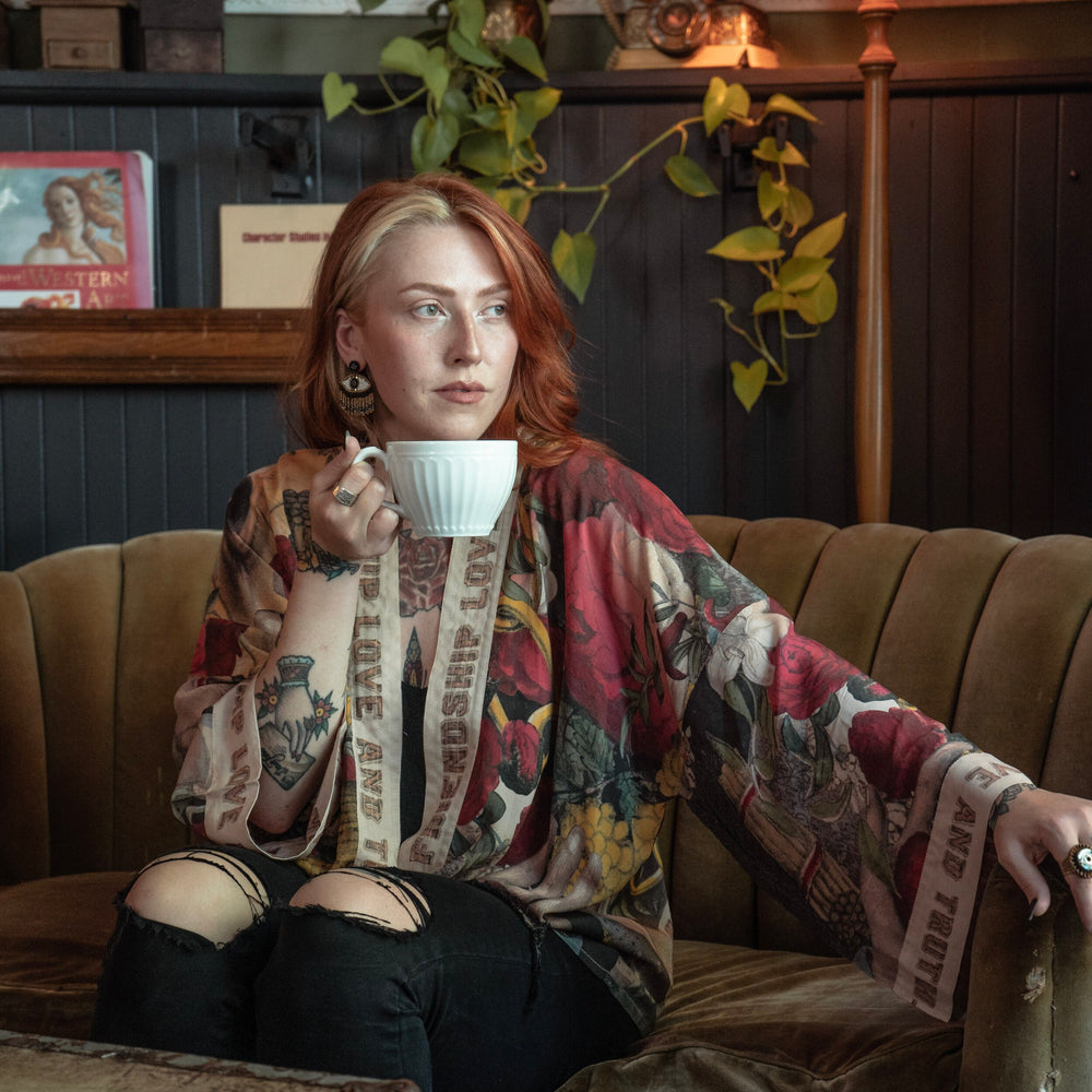 
                  
                    Model wearing our cropped kimono featuring historic symbols of friendship, love, and truth with archive-inspired wood-grain trim and romantic vintage details – Market of Stars.
                  
                