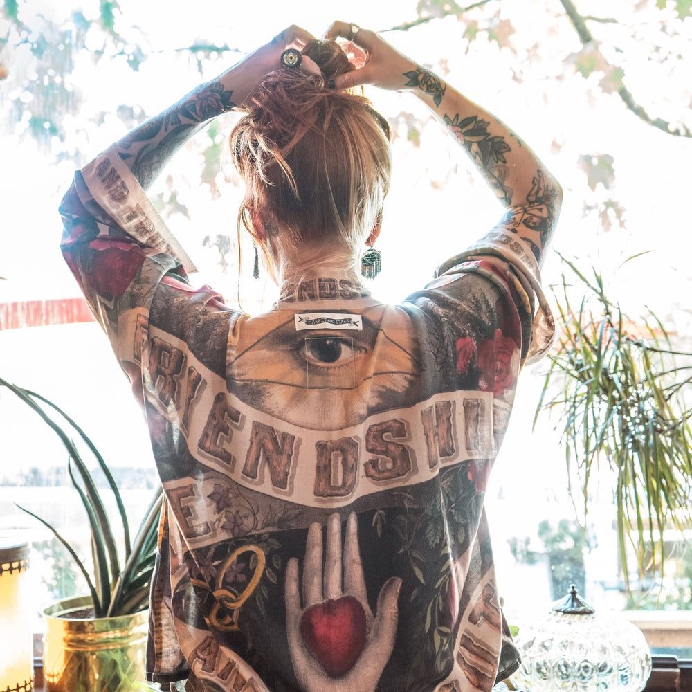 
                  
                    Model wearing our cropped kimono featuring historic symbols of friendship, love, and truth with archive-inspired wood-grain trim and romantic vintage details – Market of Stars.
                  
                