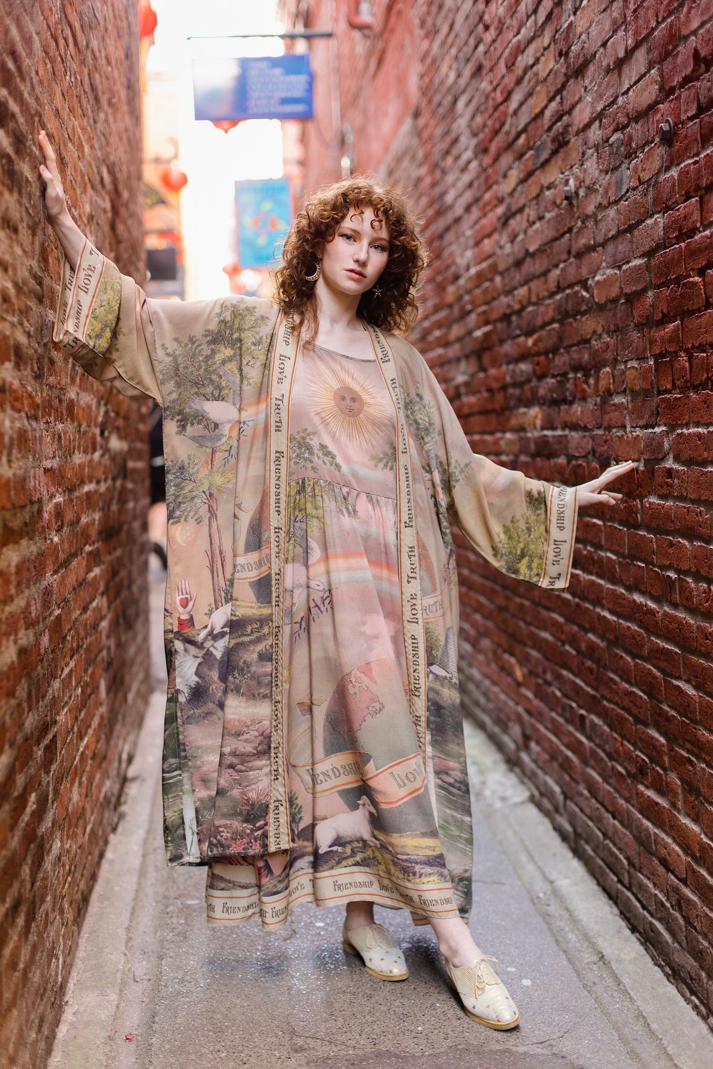 Model wearing sun-washed vintage-inspired Opera Duster featuring symbols of friendship, love, and truth in soft lavender, sage, gold, and aqua – Market of Stars