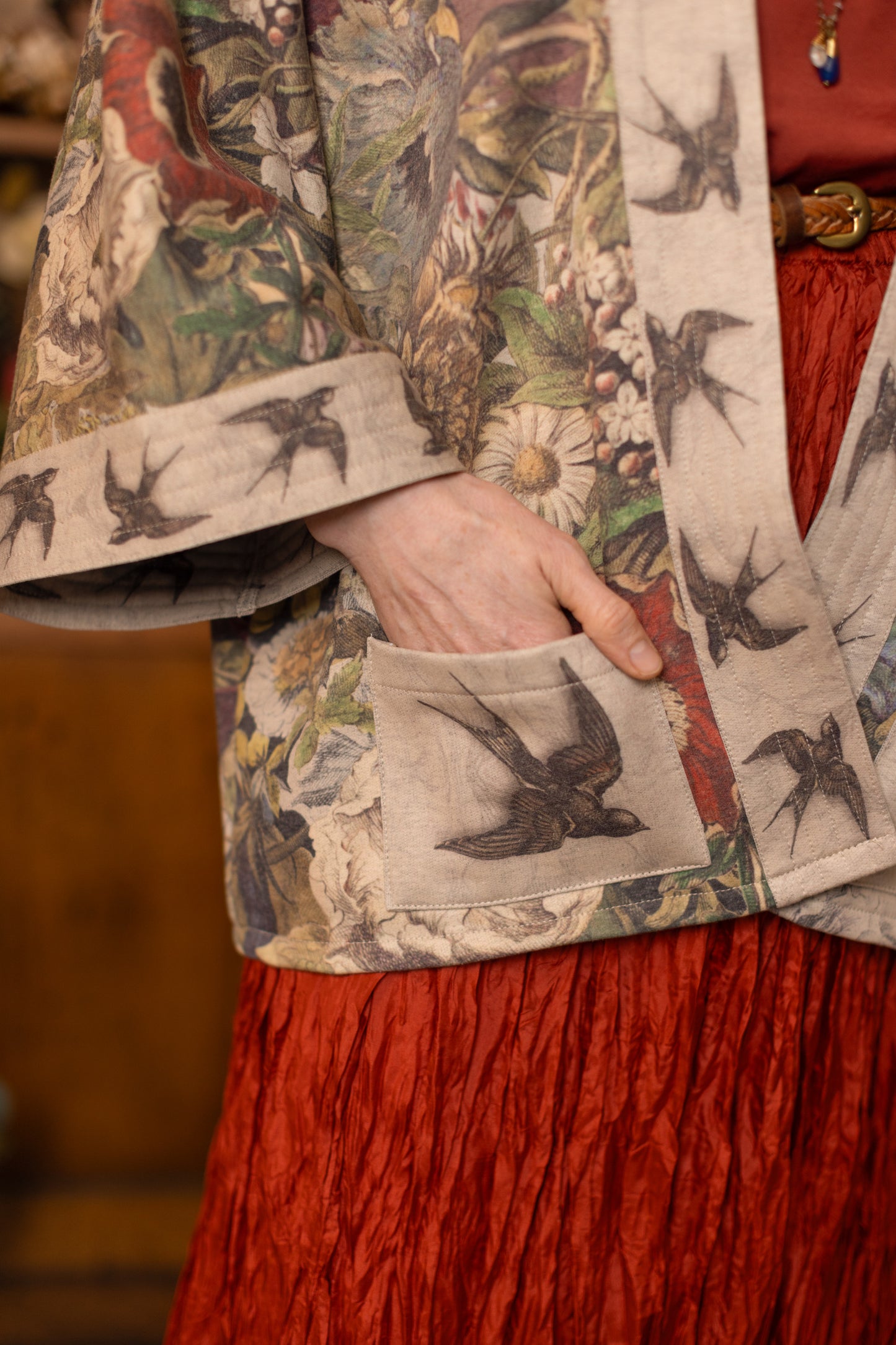 Model wearing a soft fleece cottage cardigan featuring rich 1700s botanical blooms and swallow trim - Market of Stars