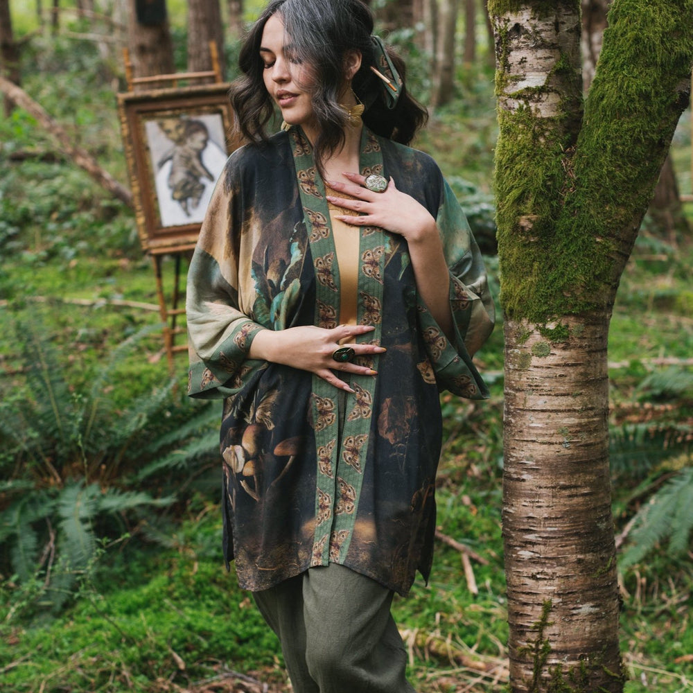 Model wearing the Heartwork Cropped Kimono featuring Artemisia Gentileschi’s self-portrait with lush forest, birds, and butterflies – Market of Stars.