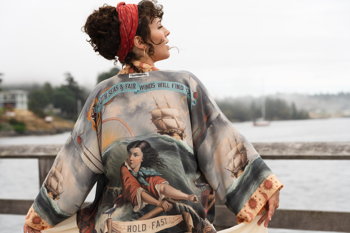 Model wearing the Hold Fast Pixie Duster featuring a Victorian woman rowing through a storm, seagulls, and rainbow horizon – Market of Stars.