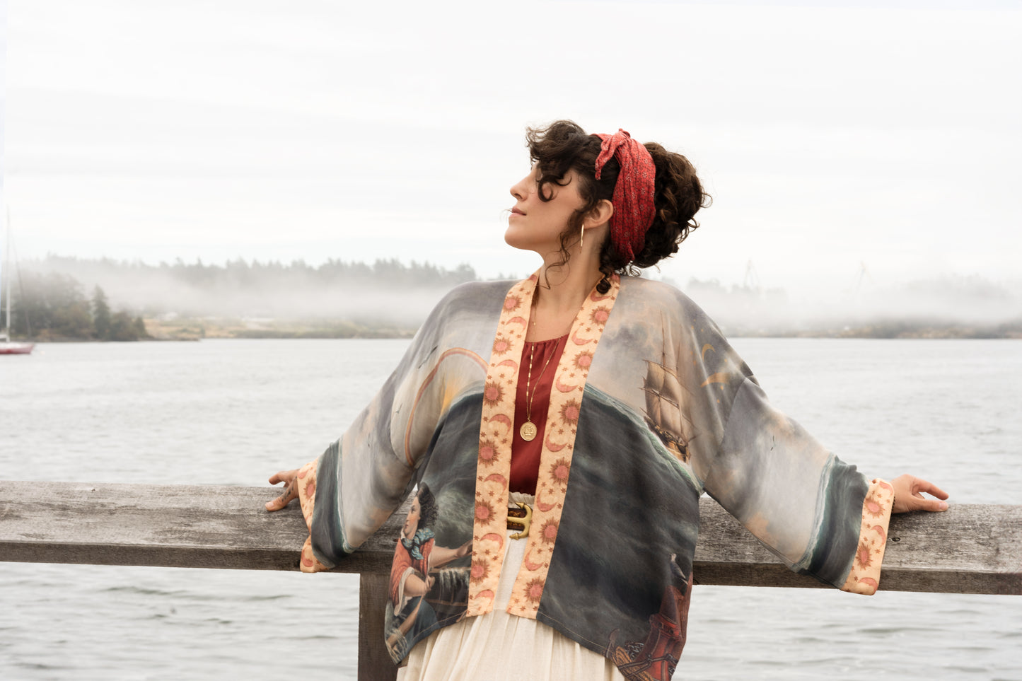 Model wearing the Hold Fast Pixie Duster featuring a Victorian woman rowing through a storm, seagulls, and rainbow horizon – Market of Stars.